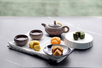 Mooncakes and Tea - 4 flavors : Durian-Salted Egg, Matcha Red Bean, Sweet Potato and Salted Egg Custard, A traditional Chinese dessert typically eaten during The Mid-Autumn Festival in China.