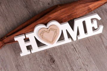 Word Home in white letters on dark wooden background