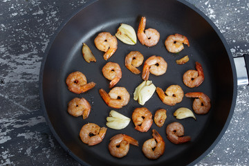 Fried peeled shrimp with garlic in a pan.