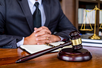 Judge gavel with Justice lawyers having team meeting at law firm background. Concepts of Law and...