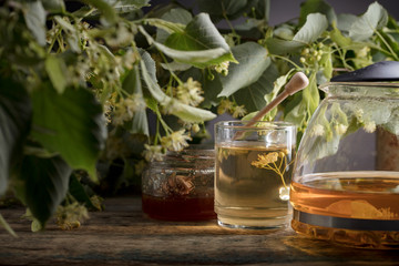 Glass of linden tea with honey  on wooden table.