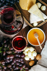 Obraz na płótnie Canvas Cheese and wine, Decanter and glasses, wooden background, appetizer, grapes