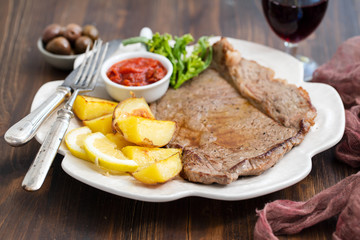 grilled meat with potato and sauce on white dish