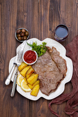 grilled meat with potato and sauce on white dish