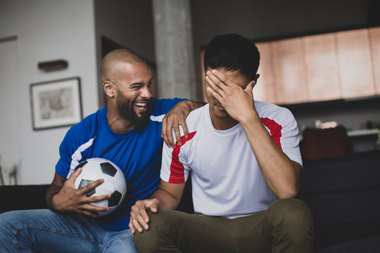 Male friends watching a football match