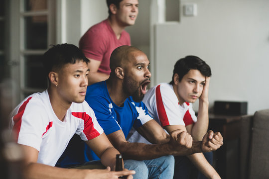 Group of male friends watching a football match