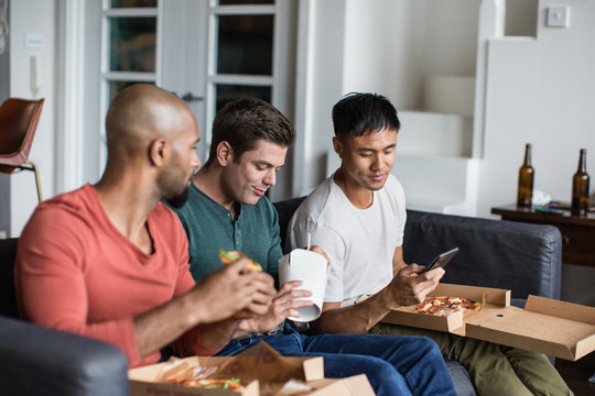 Male friends eating different takeout meals together