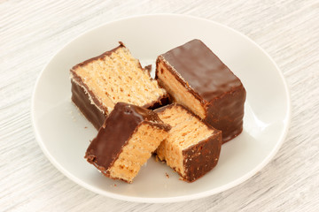 Chocolate coated wafers dessert sliced in porcelain plate