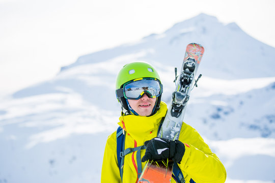 Photo of man wearing helmet wearing glasses with skis
