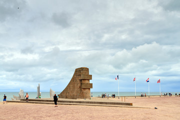 Tourists visit the D-day monument on Omaha beach in Normandy, France, on August 2, 2014
 - obrazy, fototapety, plakaty