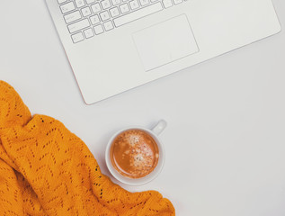 Computer, coffee and yellow sweater on the white background.