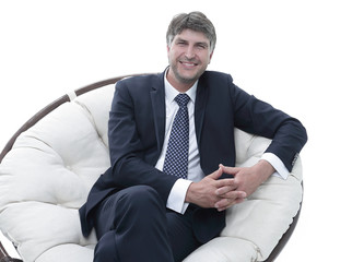 Successful businessman sits in a soft comfortable chair.