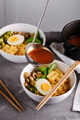 Japanese ramen soup with tofu, vegetables and egg. Miso soup with ramen noodles and tofu in ceramic bowl, asian traditional food.