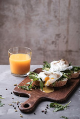 Poached eggs on toasted baguette slices with avocado and arugula