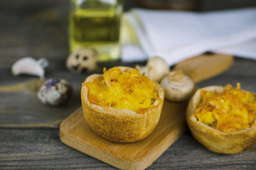Baked puff pastry with potato filling and cheese on a wooden board