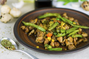 fried meat with vegetables and asparagus with spices on a plate