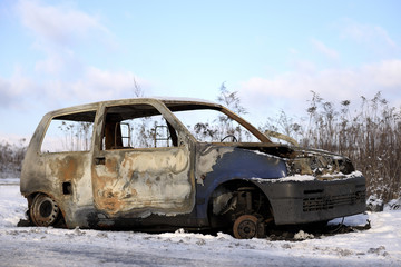 Spalone auto stojące przy drodze zimą. - obrazy, fototapety, plakaty