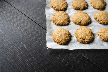 Homemade cookies on baking paper, black background