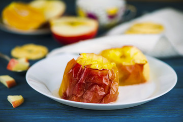 Baked apple with cheese on a plate on a wooden board