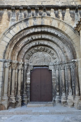 The Romanesque entrance of the Nicholas of Bari Church (Iglesia de san Nicolas de Bari), with the typical low reliefs in the small rural Aragonese town of Frago, Spain