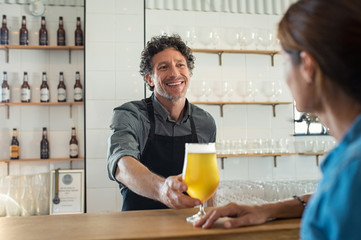Bartender serving beer to woman