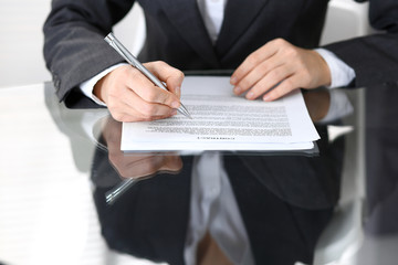 Close-up of female hands with pen over document of contact, business concept