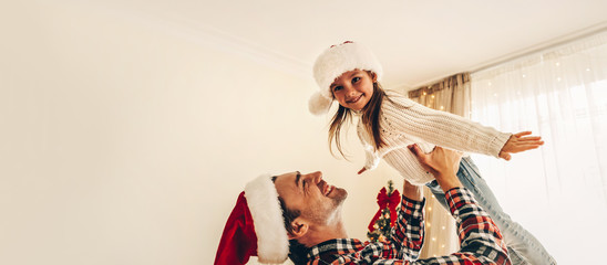 Christmas. Family. Fun. Dad is playing with his little daughter near the Christmas tree at home....