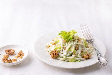 Traditional Waldorf salad with celery, apple, walnut and yoghurt dressing on white background,...