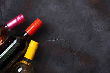 Bottles of red white and pink rose wine on stone kitchen table background. Top view. Space for text