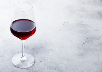 Elegant glass of red wine on stone kitchen table background.