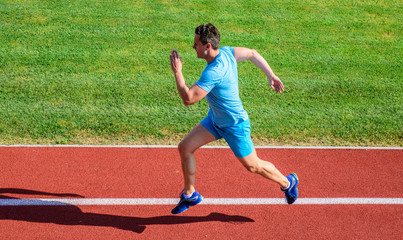 Sprinter training at stadium track. Progress and achievement. Training before take part in marathon. Man captured in motion. Sprinter athlete run training. Athlete run track grass background