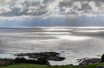 A landscape of a cloudy stormy sea and a grass lawn from Parque de Bens in Galicia capital city La Coruña
