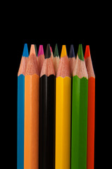 Assortment of colored pencils isolated on black background