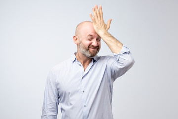 Mature european bearded young male dressed in casual white shirt trying to remember where he put...