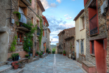 Fototapeta na wymiar A landscape of the main drag (calle mayor) in Alcalá del Moncayo town in Aragon, Spain, during autumn, with green ivy climbing on the bricks walls of a traditional stone made houses