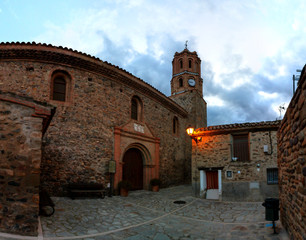 Fototapeta na wymiar A landscape of the brick Assumption Church (Iglesia de la Asumpcion), in spanish typical romanesque and barroque style, in the small traditional town of Alcalá del Moncayo in Aragon, Spain, at sunset
