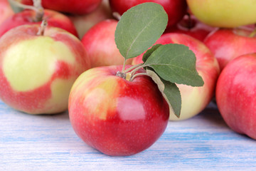 fresh red apple with green leaves close-up on blue wooden table