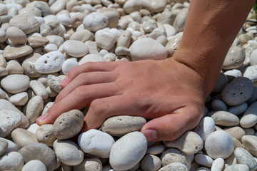 close up of a hand on a stone beach