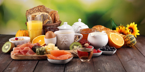 breakfast on table with bread buns, croissants, coffe and juice. - obrazy, fototapety, plakaty