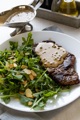 steak with arugula and green peppercorn sauce