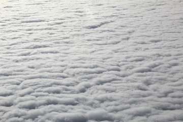 An areal view of flat uniform homogeneous clouds and a deep blue sky as as seen from an airplane