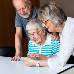 Three elderly persons using smart phone