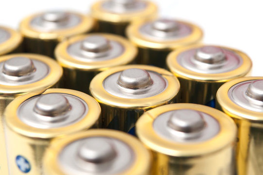closeup of golden and silver aa alkaline batteries group on white background
