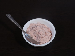 Black Salt Powder, black ground salt from the Himalayas heap pile close up isolated ,Indian Black salt, Kala namak,,Kala namak or Black salt,Black salt in white bowl on wooden background,