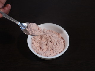 Black Salt Powder, black ground salt from the Himalayas heap pile close up isolated ,Indian Black salt, Kala namak,,Kala namak or Black salt,Black salt in white bowl on wooden background,