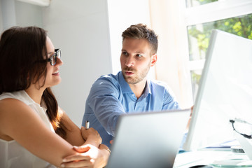 Two Businesspeople Looking At Computer