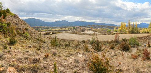 Blue cloudy sky and typical mountains and hills covered with forest met in autumn while hiking from the small Yebra de Basa town to Santa Orosia church on the Pyrenees mountains, Aragon, Spain
