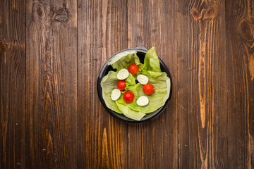 lettuce leaves with cherry tomatoes and quail eggs on a plate