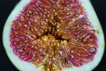 Cross section of a fresh ripe halved fig fruit, macro photo.