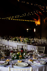 hall with table set for wedding party lit candles